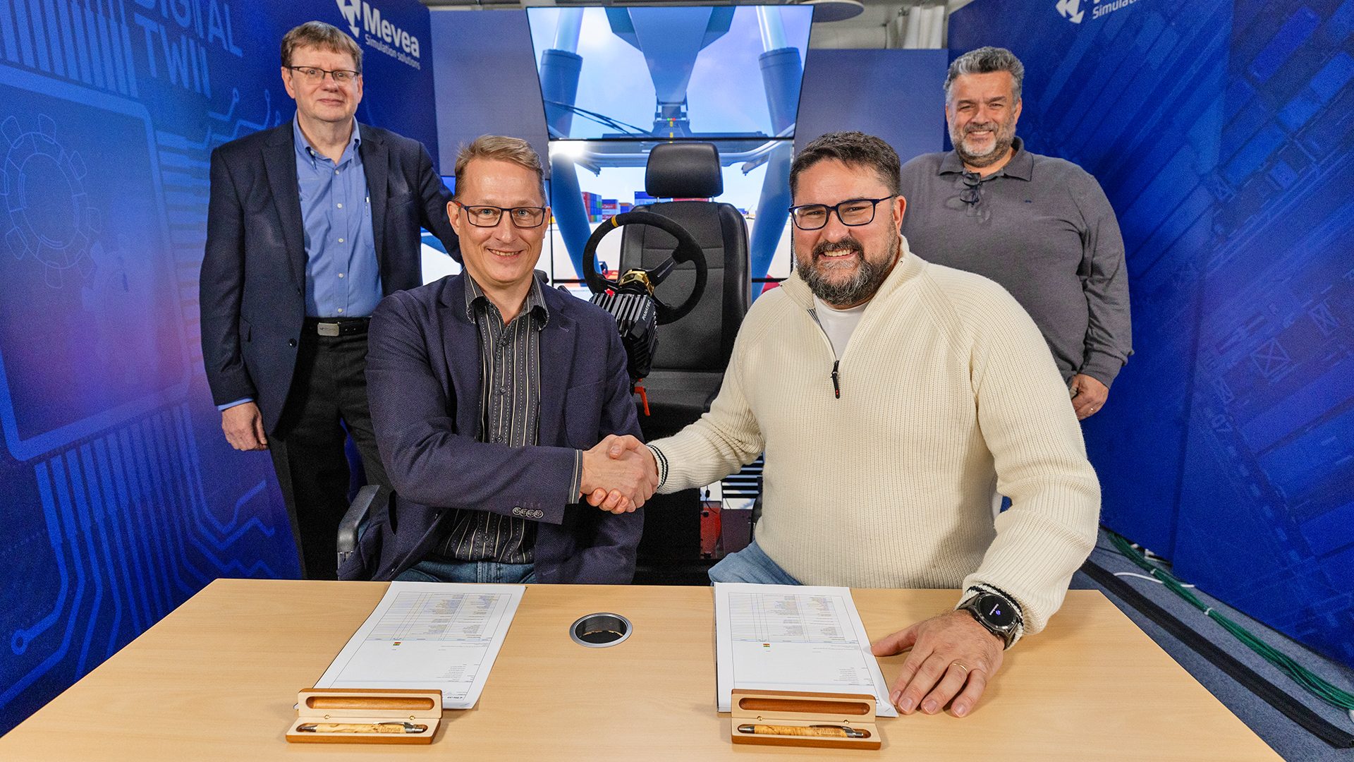Managing Directors Tero Koskipalo (Mevea) and Emanuele Pitto (Scenario) signing the partnership. Witnessing in the background: Raimo Nikkilä (Mevea) and Massimo Gobbo (Scenario).