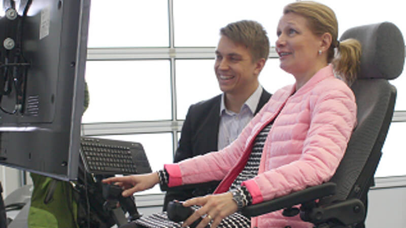 Finnish Minister for European Affairs and Foreign Trade Lenita Toivakka testing one of the latest Mevea simulators at Mevea office.